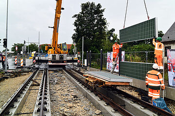 Kran baut Solaranlagen an den Rand der Straßenbahn Schienen. - Beim anklicken wird das Bild vergrößert.