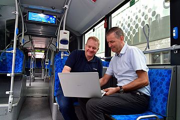 Zwei Männer stecken eBus zum Laden an